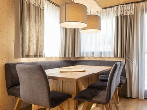 Un coin repas avec une table en bois et quatre chaises rembourrées.