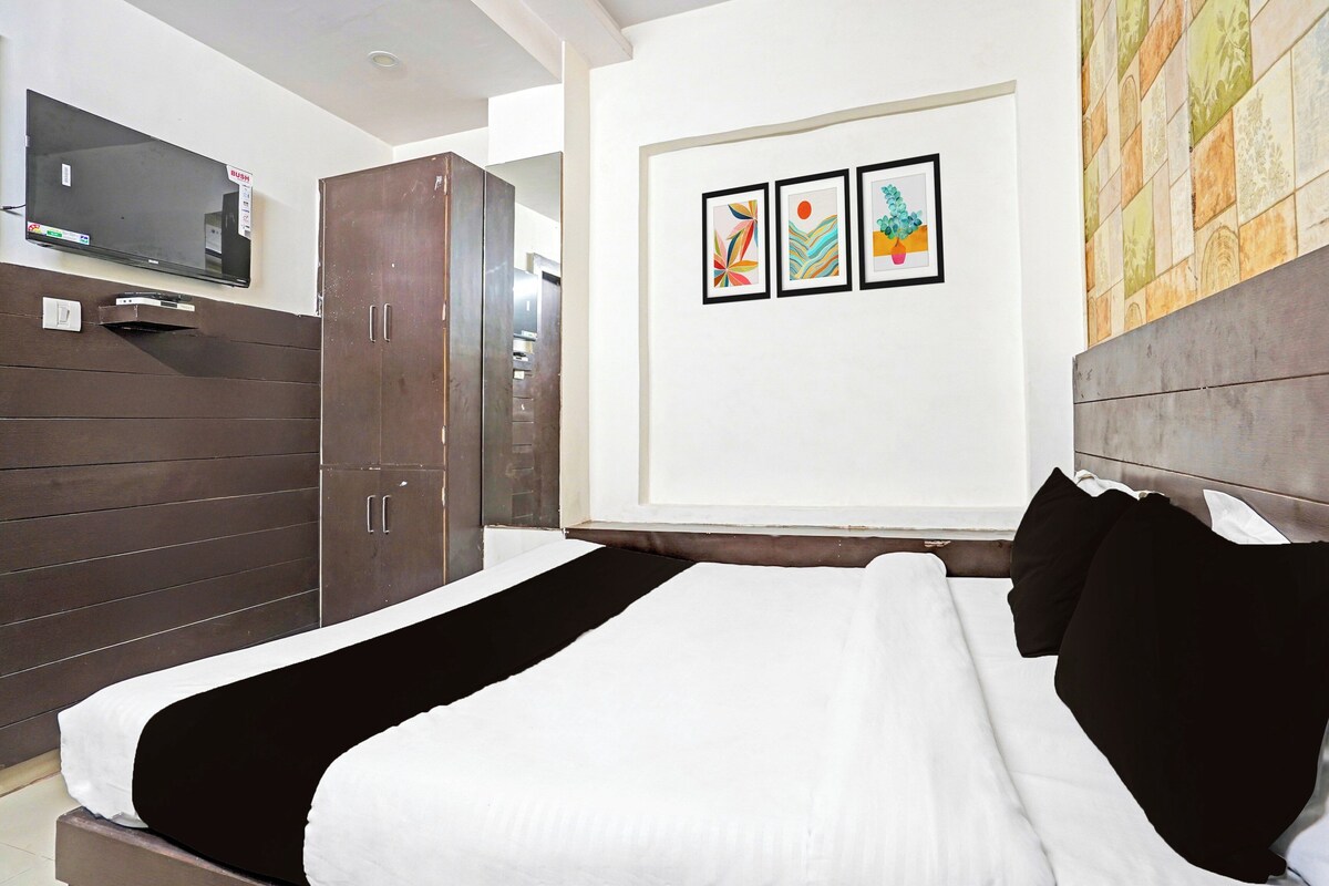 Una habitación de hotel con cama, armario y televisión de pared.