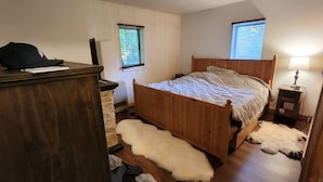 Un dormitorio con cama de madera, un escritorio y una lámpara.