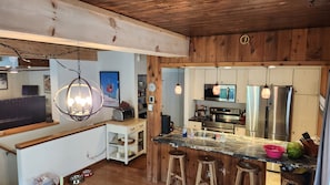Una cucina con pareti in legno, un piano di lavoro in marmo ed elettrodomestici in acciaio inossidabile.