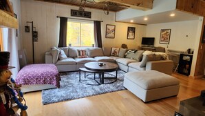 Una sala de estar acogedora con un sofá, una mesa de centro y un televisor.