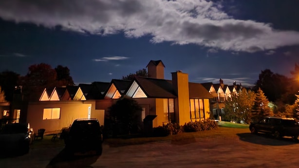 Filas de casas con techos a dos aguas y un cielo nocturno despejado con luna visible.