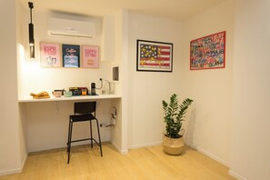 A small kitchenette with a coffee machine, a kettle, and a toaster. There is a chair and a potted plant. - Filo Guesthouse (Roma)