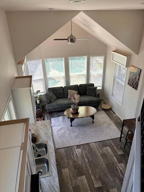 A compact living space with a loft bedroom, a dining area, and a kitchen. - Scenic Mountain Glampground with Dark Sky Stargazing Near Forest Trails in Fruitland, Utah (Fruitland)