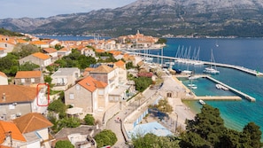 A coastal town with traditional architecture, a marina, and a mountainous backdrop. - A2 - Apartment 50m from the beach with the sea view (Korcula)