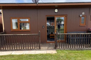 A brown building with a wooden door, a window, and a satellite dish.
