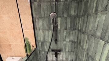 A bathroom with a glass-enclosed shower, a toilet, and a sink.