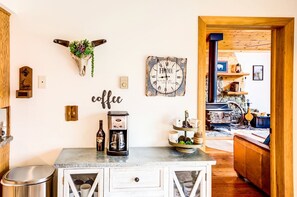 Una cocina con estación de café, un reloj de pared rústico y decoración de madera.