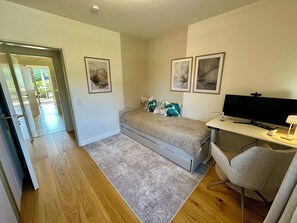A bedroom with a bed, a desk with a computer, and two framed pictures on the wall. - Newly renovated Berggold Chalet with the Chiemgau Card in the heart of Chiemgau (Siegsdorf)
