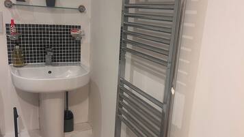 A bathroom with a white sink, mirror, and a towel rack.
