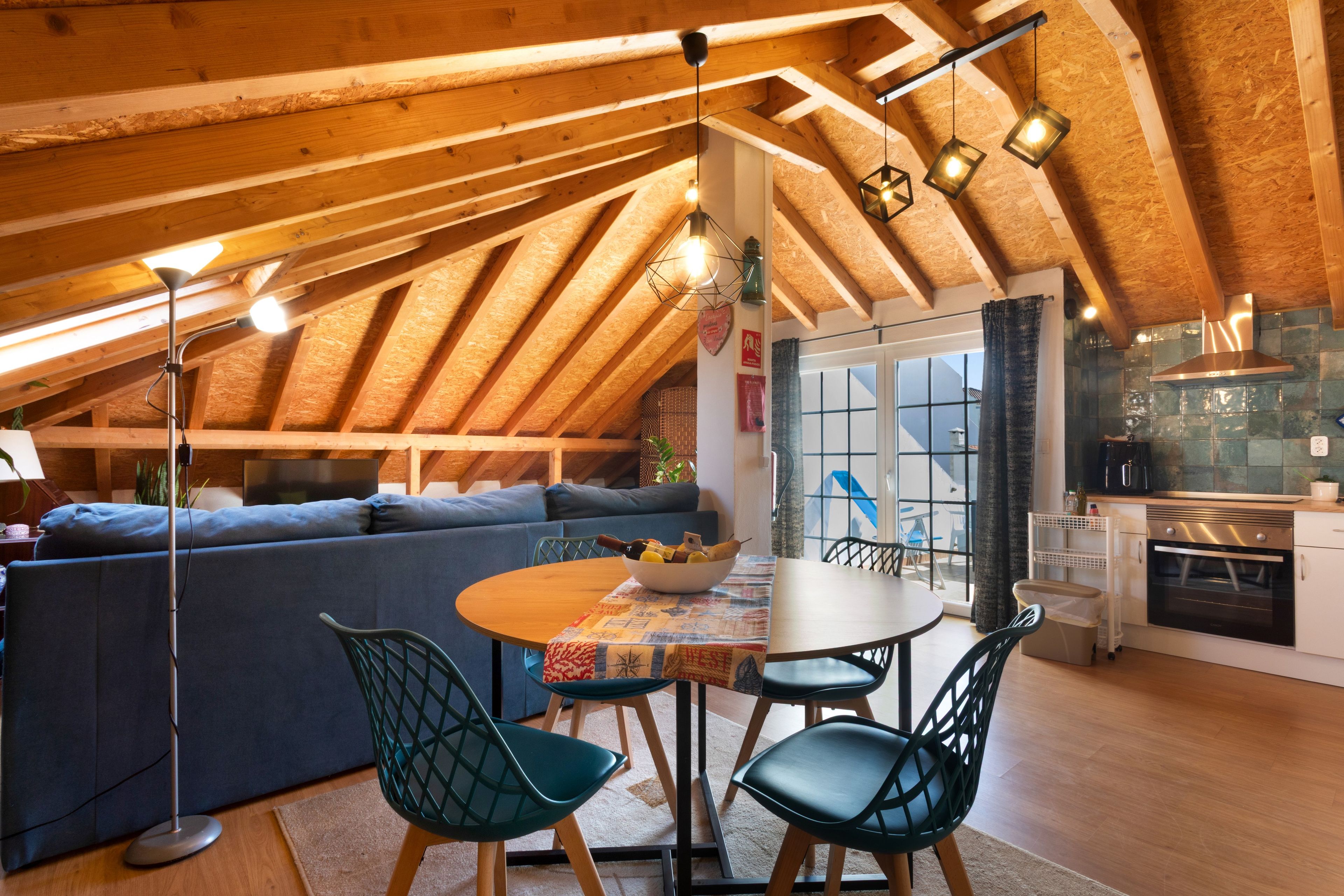 Un acogedor dormitorio en el ático con comedor, sofá y cocina.