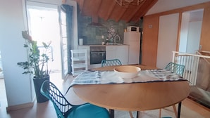 A dining area with a round table, chairs, a bowl, and a potted plant. - 'Waves Inn' Surf, Beach & Relax. With Wi-Fi (Silveira)