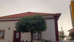 A building with a red-tiled roof, a white facade, and a tree in front. - 'Waves Inn' Surf, Beach & Relax. With Wi-Fi (Silveira)
