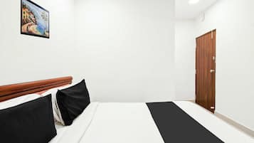 Habitación de hotel con cama, cabecero de madera, un cuadro en la pared y un armario.