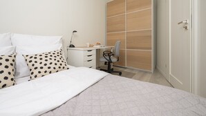 Un dormitorio con cama, escritorio, silla y armario.