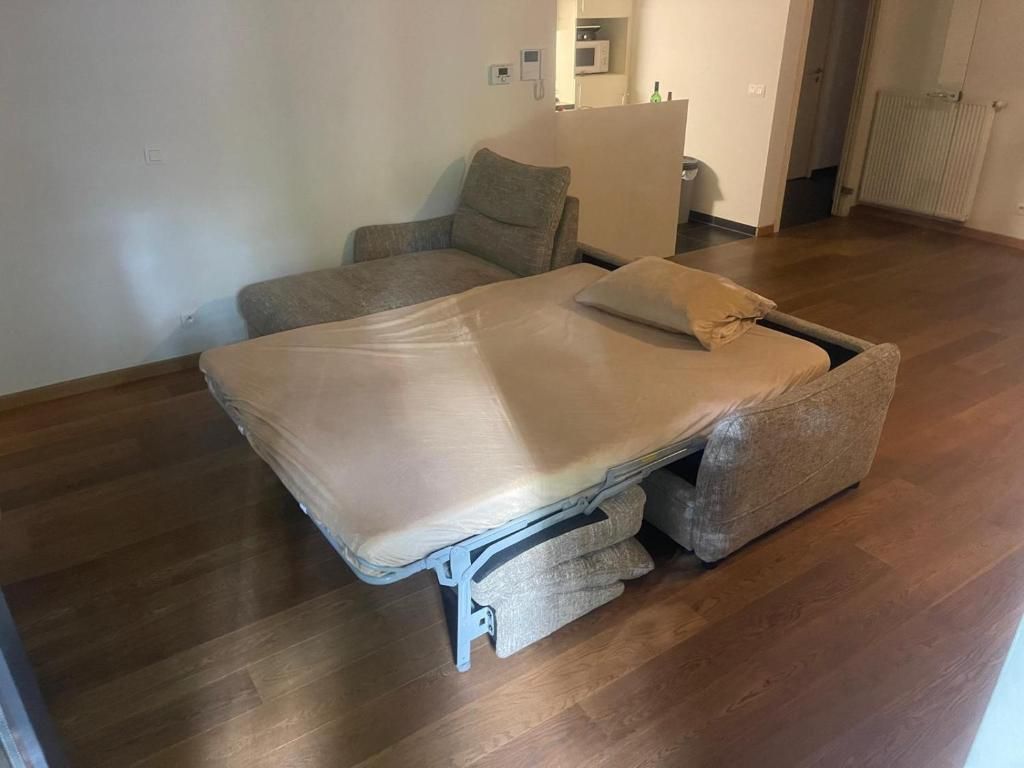 Een kamer met een bed, een stoel en een klein tafeltje.