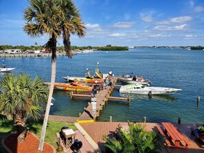 A marina with boats docked, a wooden pier, and palm trees. - Bay to Gulf Townhouse on Manasota Key (Englewood)