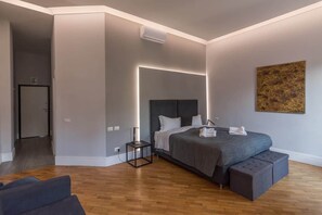 Ein modernes Hotelzimmer mit einem großen Bett, einem Nachttisch und einer Bank.