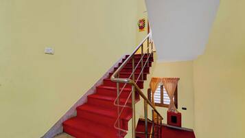 A staircase with red steps and metal railings leading to a landing.