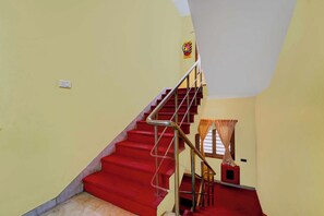 A staircase with red steps and metal railings leading to a landing.
