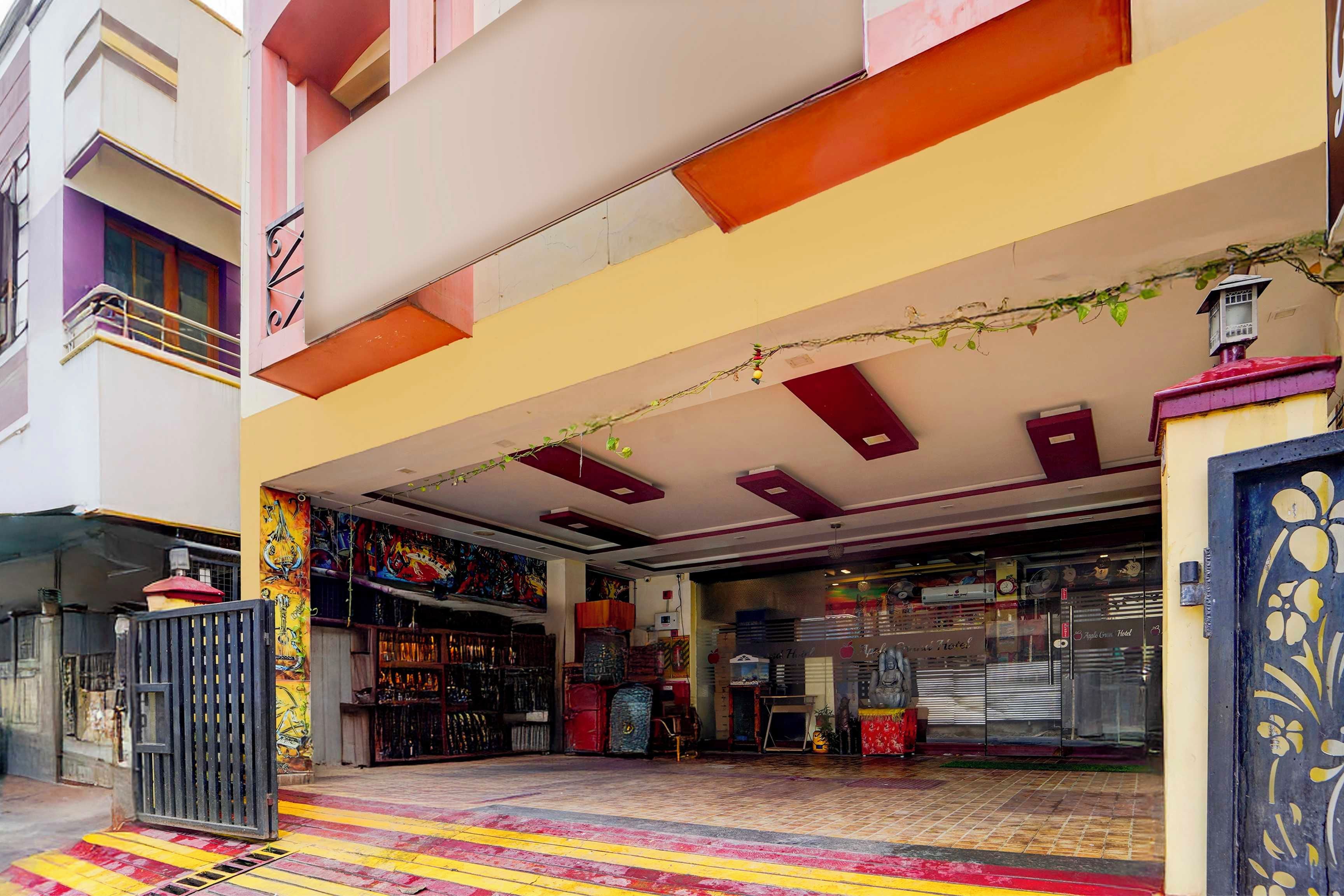 A hotel entrance with a colorful awning, a gated entrance, and a storefront with various items on display.