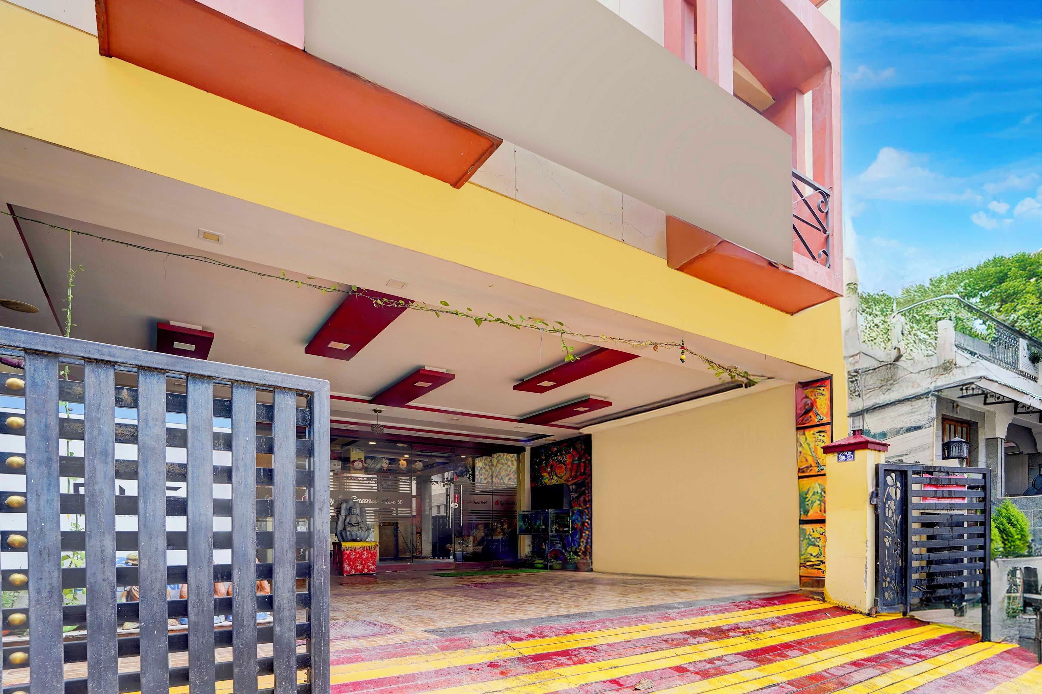 Entrada de hotel con zona techada, piso de baldosas y un portón.