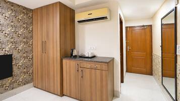 A compact kitchen with wooden cabinets, a built-in stove, and an air conditioning unit.