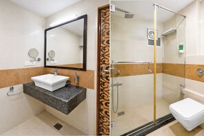 Une salle de bain avec un lavabo, un miroir et une douche.