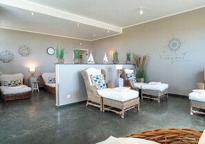 A modern interior with wicker furniture, a central island, and decorative wall elements. - Sea View Villa, Apartment 9 "beach Love" (Grossenbrode)
