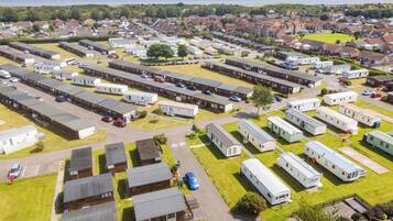 A large caravan park with multiple rows of caravans and a few larger buildings, likely service facilities.