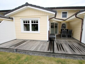 A single-story building with a covered patio area, a window, and a door. - Lapwing at Susanne-fischer-weg 31 (Wyk auf Foehr)