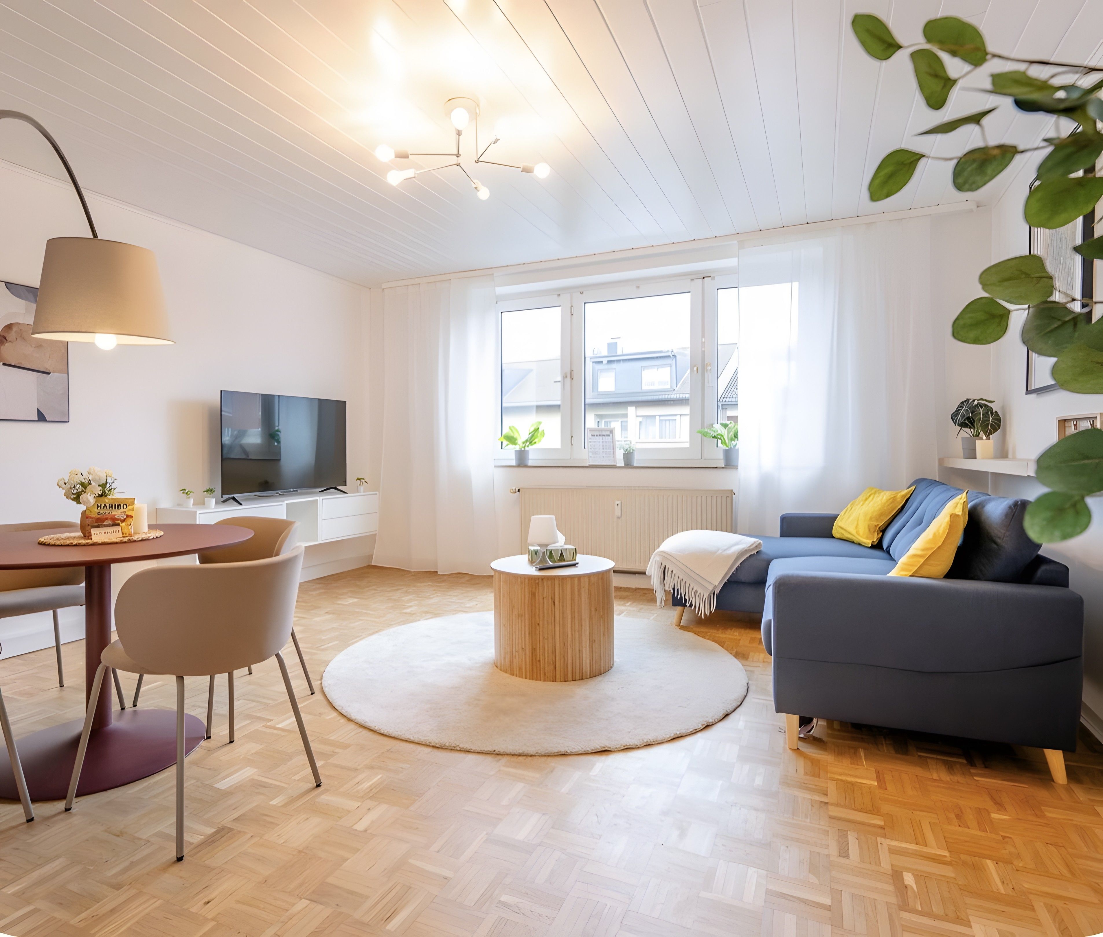 Un salon moderne avec un canapé, une table à manger et un téléviseur.