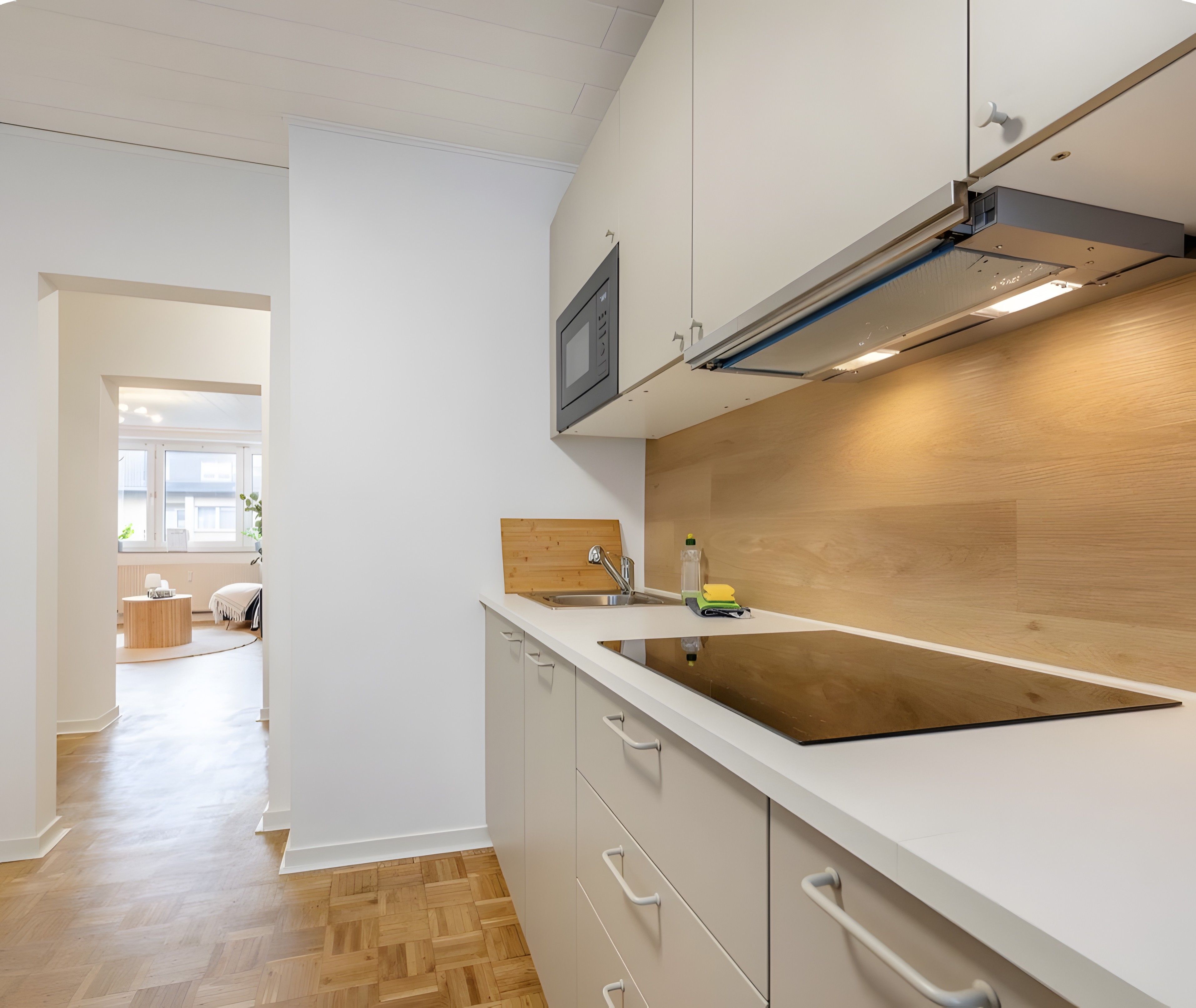 Eine moderne Küche mit einer Holzausziehtheke, einer eingebauten Spüle und einer Mikrowelle.