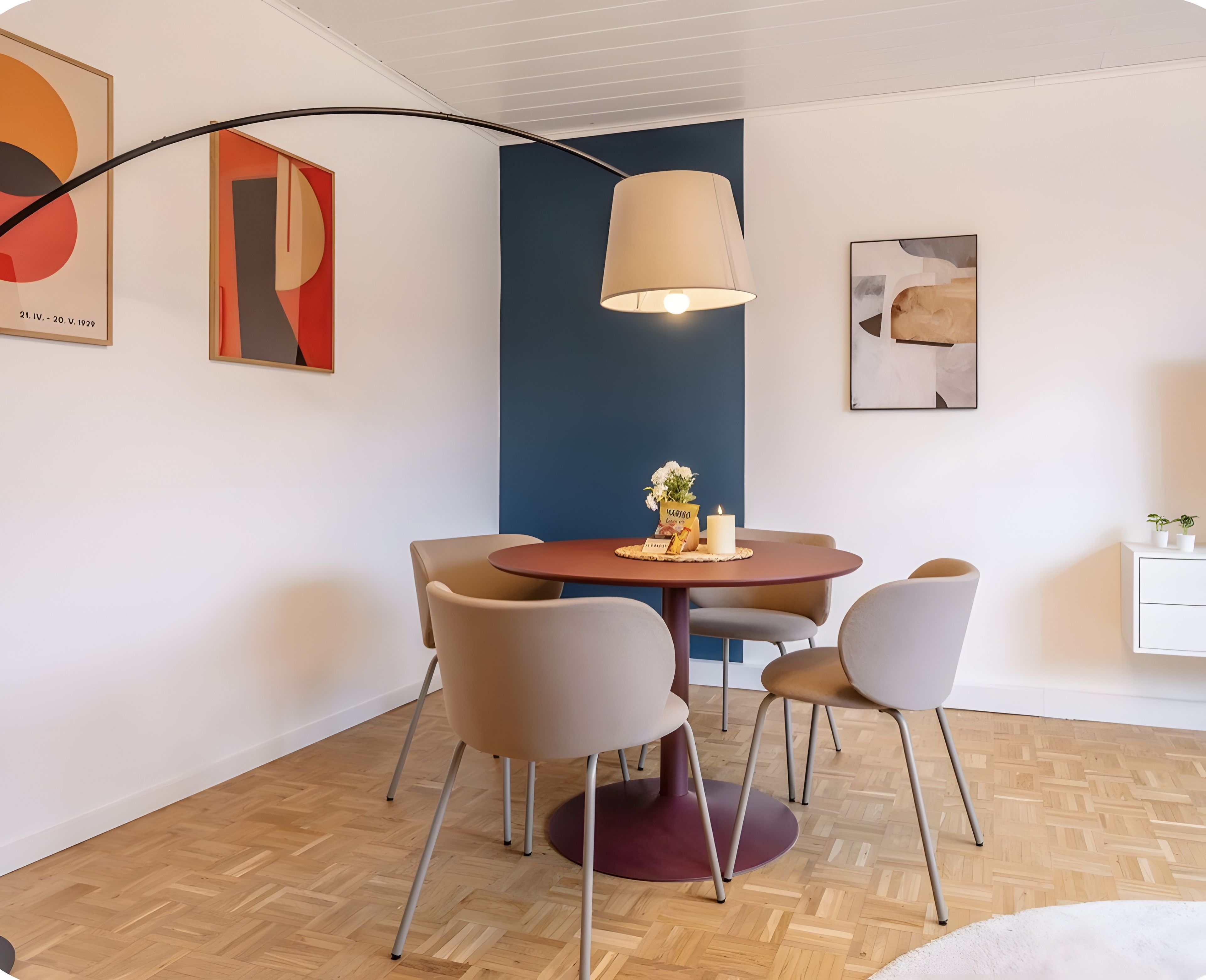 Un espace repas moderne avec une table ronde, quatre chaises et un luminaire suspendu.