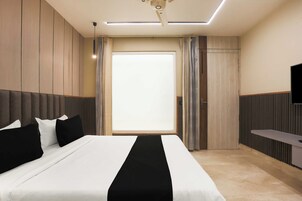 Habitación de hotel moderna con una cama grande, un televisor de pantalla plana y vistas al exterior.