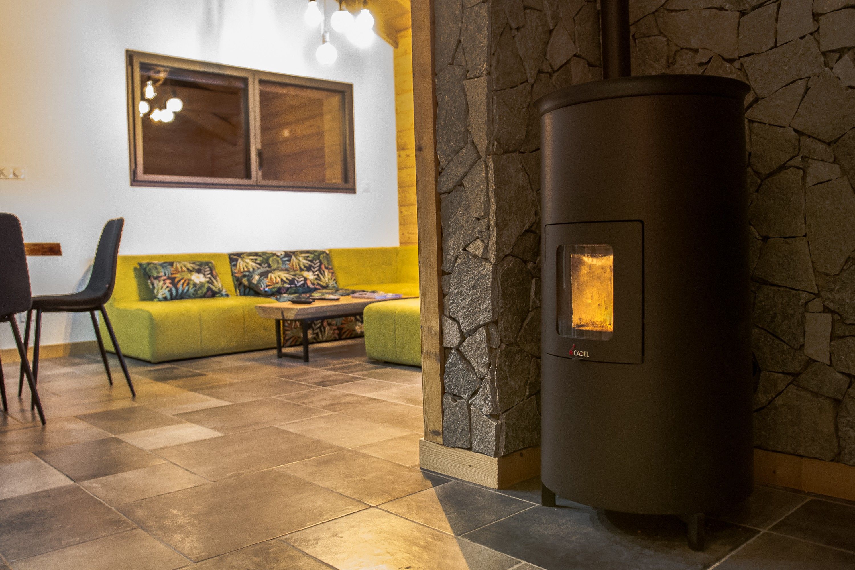 A modern interior with a stone wall, a sofa, a table, and a fireplace.