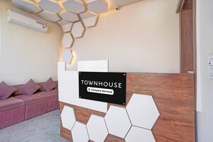 Uma área de recepção com uma placa indicando 'TOWNHOUSE Company-Serviced'.