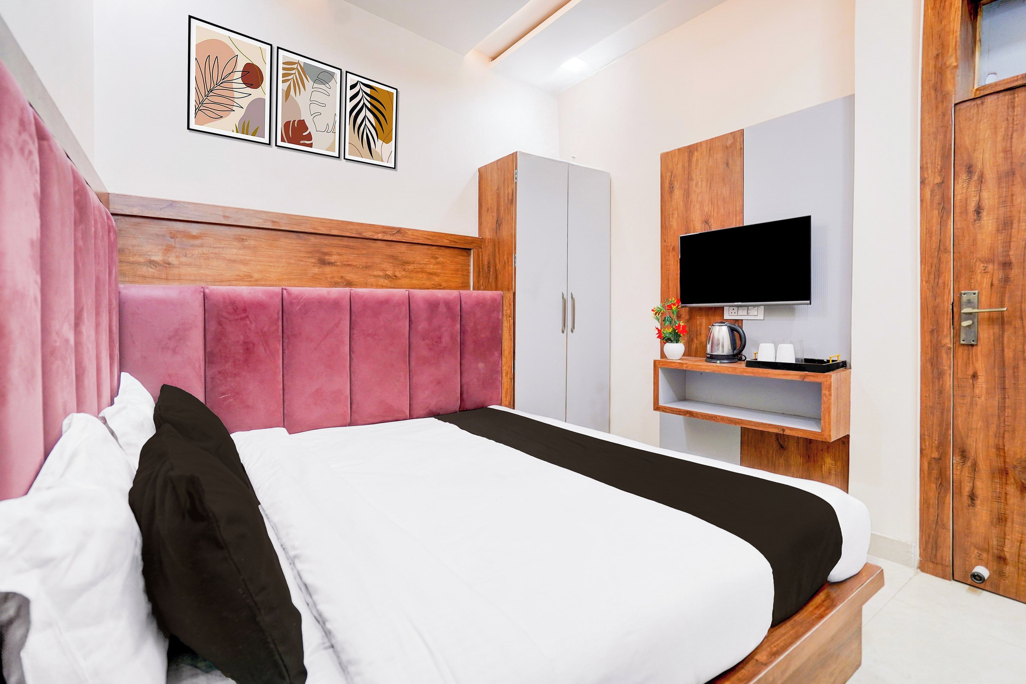 Een moderne slaapkamer met een groot bed, een kledingkast, een televisie en kunst aan de muur.