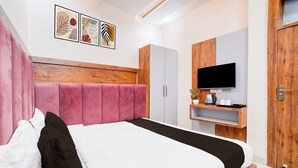 Een moderne slaapkamer met een groot bed, een kledingkast, een televisie en kunst aan de muur.