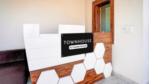 Een receptiebalie met een bord waarop 'TOWNHOUSE Company-Serviced' staat.