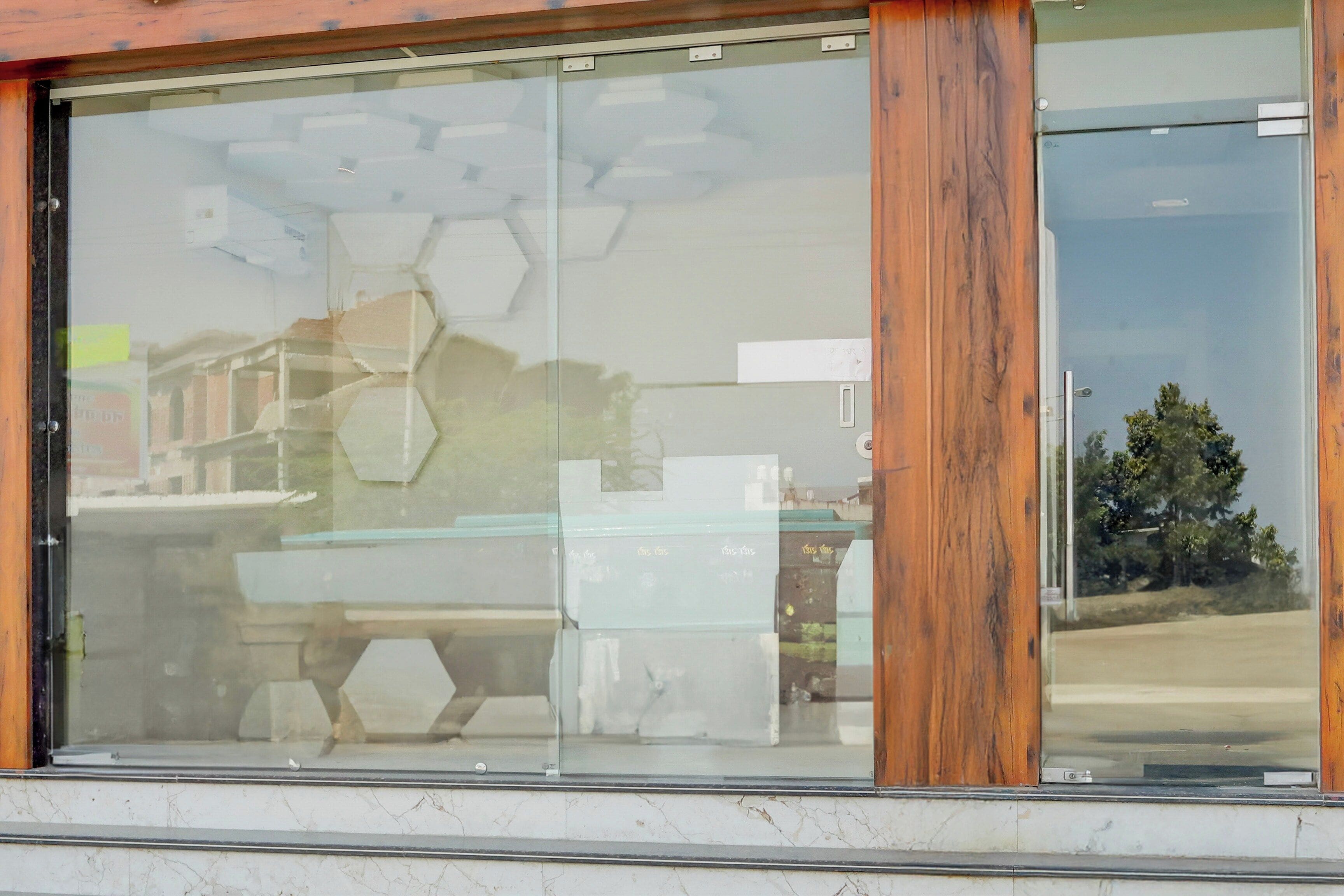 A modern building with large glass windows and wooden framing.