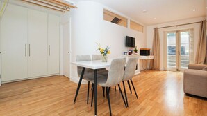 Un espacio moderno de estar con comedor, sofá y televisor.