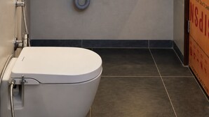 Een moderne badkamer met toilet, wastafel en douche.