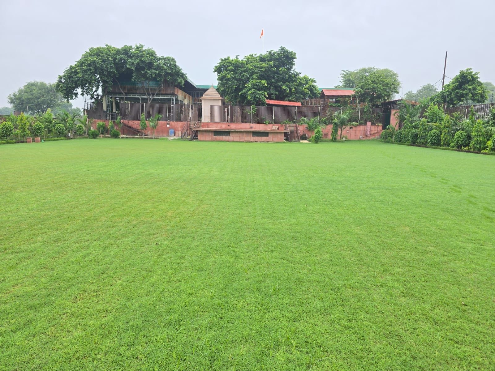 A large, open grassy area with a building in the background.