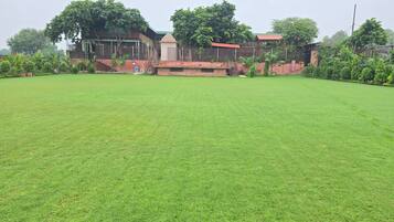 A large, open grassy area with a building in the background.