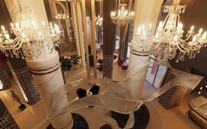 A grand lobby with multiple chandeliers, a central spiral staircase, and a large mirror reflecting the space. - Palmeraie Golf Palace by Pickalbatros (Marrakech)