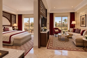 A hotel room with a bed, a sofa, a TV, and a balcony with a view. - Palmeraie Golf Palace by Pickalbatros (Marrakech)