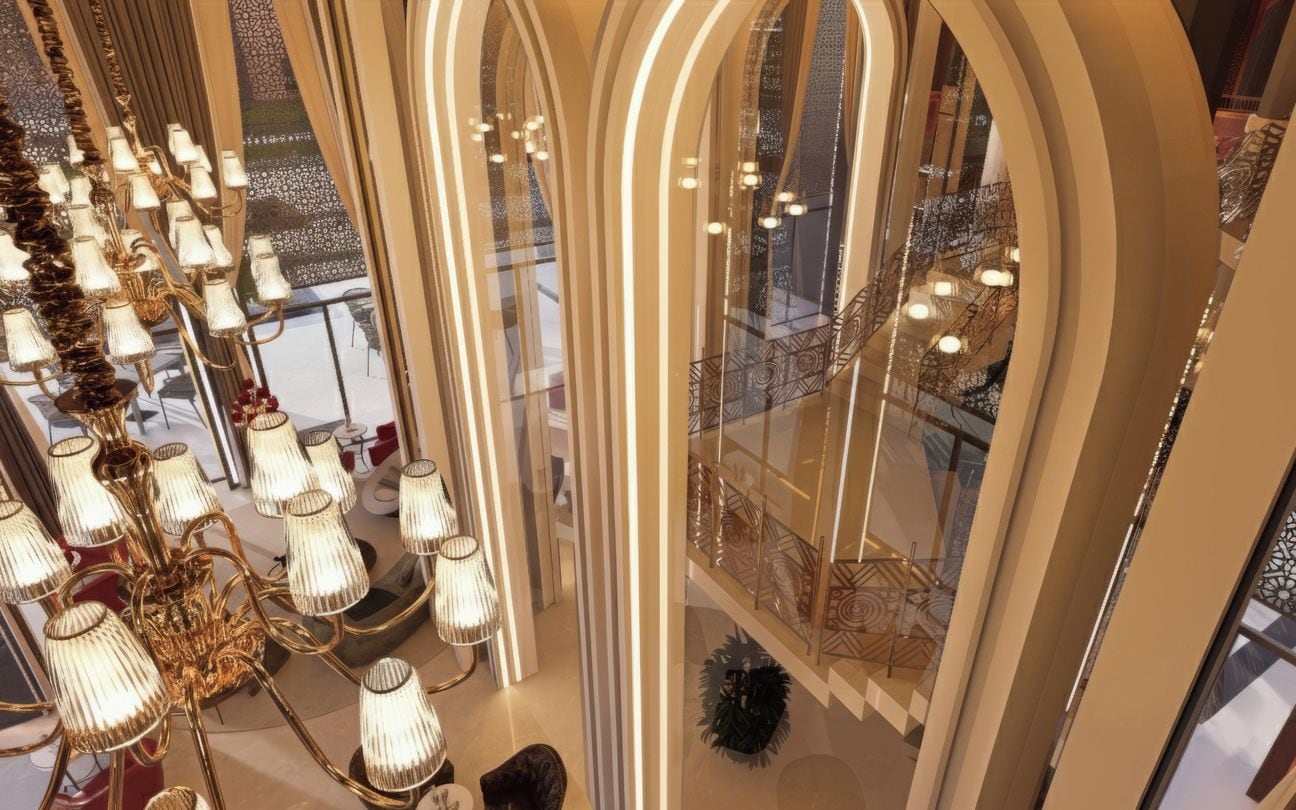 A grand interior with a large chandelier, arched windows, and a reflective floor.