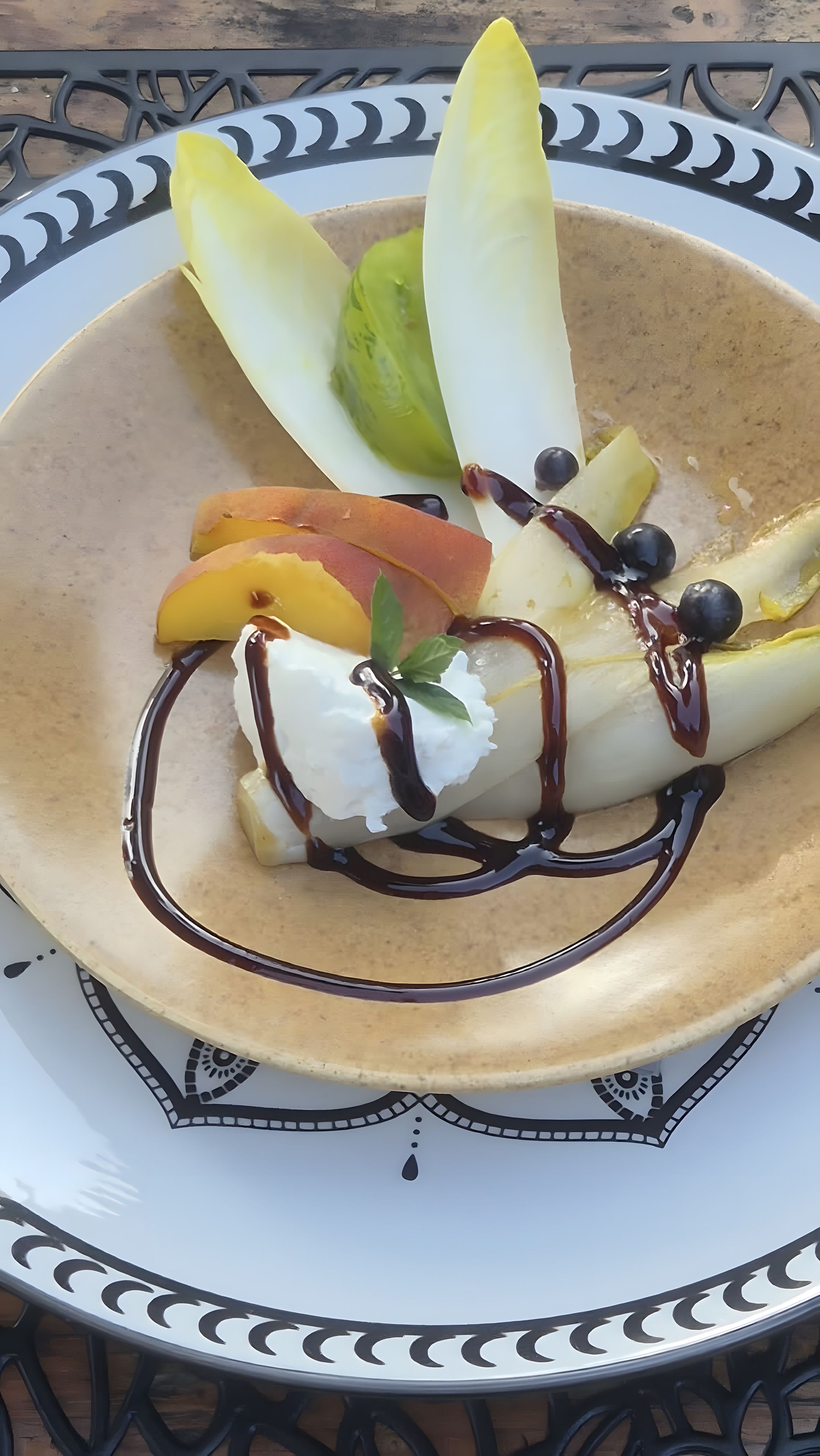 Ein Dessertteller mit einer Kugel Eis, Fruchtstücken und Schokoladendrizzle.