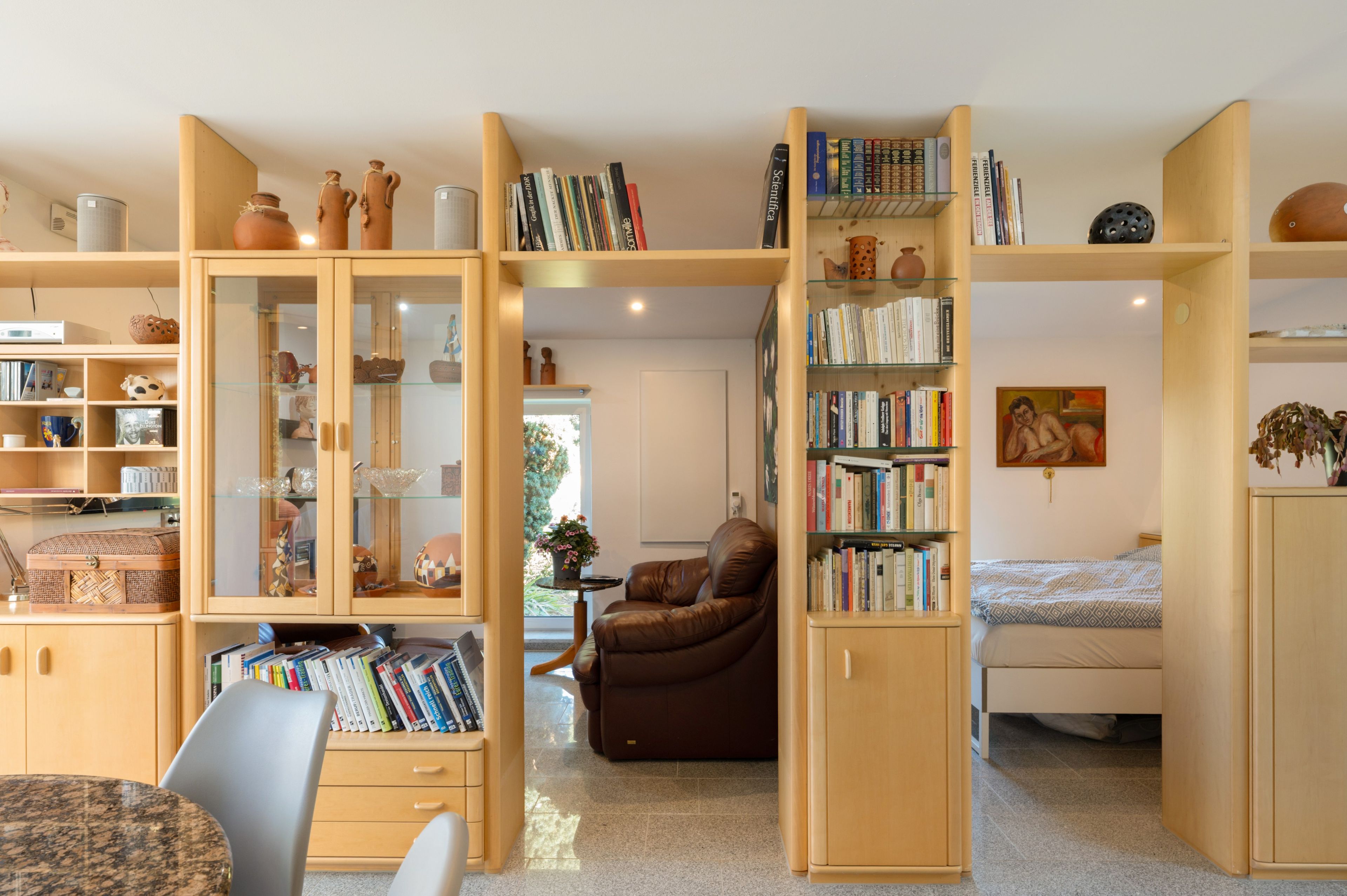 A cozy reading nook with a leather armchair, a small table, and a bookshelf filled with books.